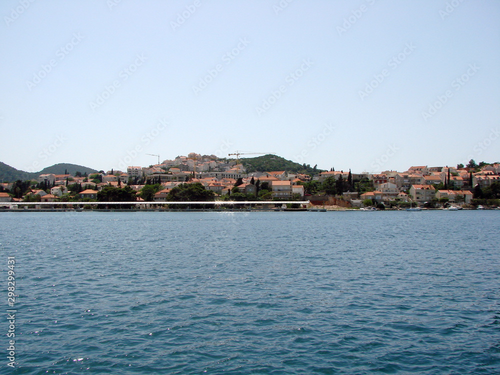View from the seaport on the coastal buildings of Dubrovnik on the opposite side of the bay against a background of blue sea and clear sky.