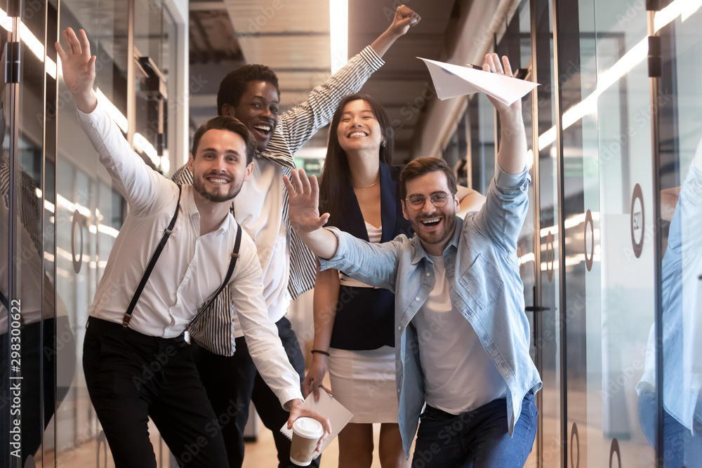 Portrait happy diverse employees celebrating business victory in hallway - obrazy, fototapety, plakaty 