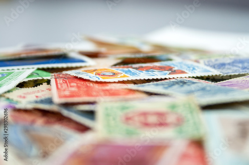 Closeup view on a variety of multi-colored postage stamps from different countries and years. Selective focus photo