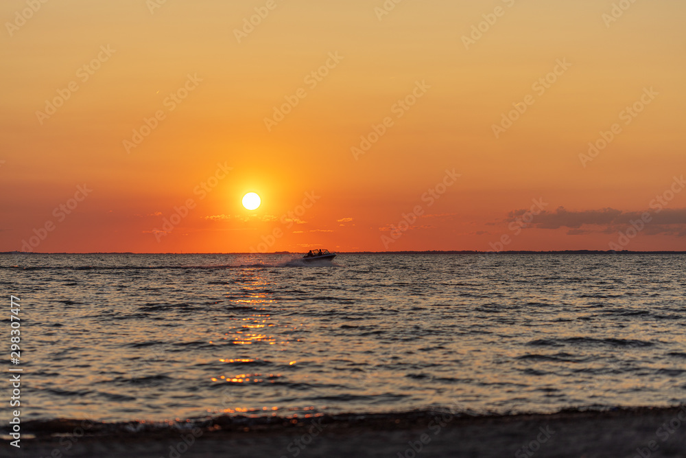 Sunset on beach over water boat