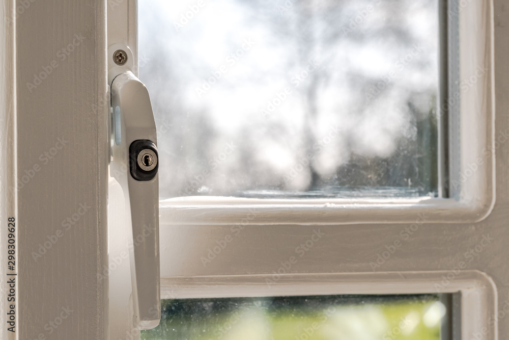 View to the outside from a newly installed, home office double glazed window showing detail of the security latch seen in the locked position View to the outside from a newly installed, home office double glazed window showing detail of the security latch seen in the locked position