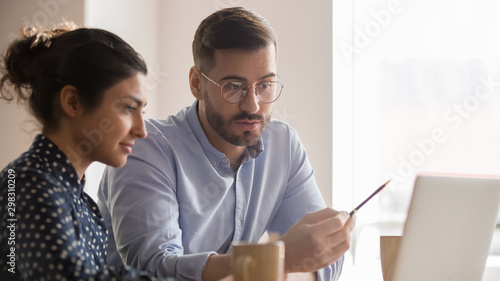 Young diverse couple of office employees working together