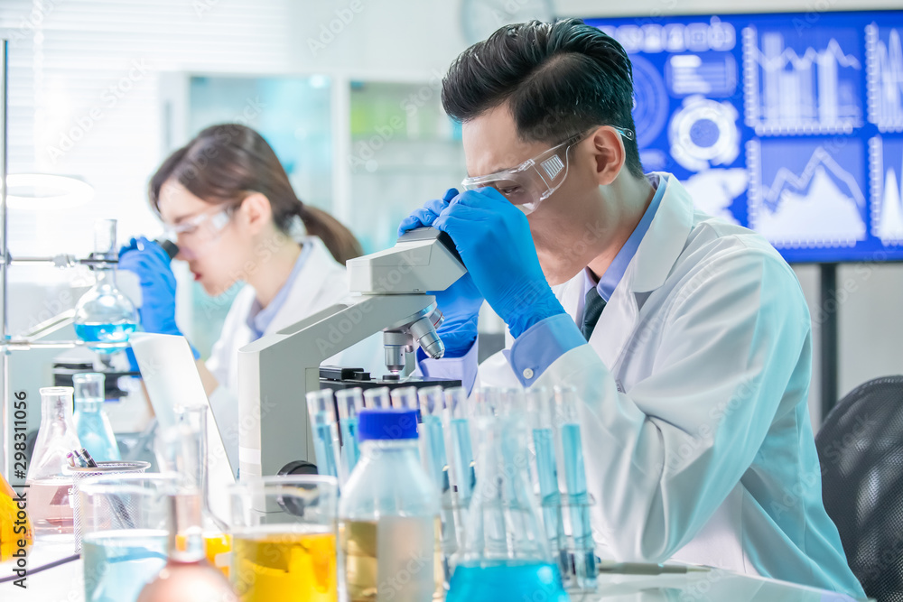 Asian scientist use microscope Asian scientist use microscope