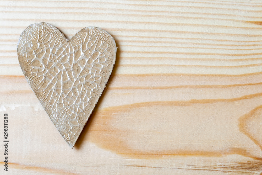 Cardboard heart with cracks lying on a wooden background Cardboard heart with cracks lying on a wooden background