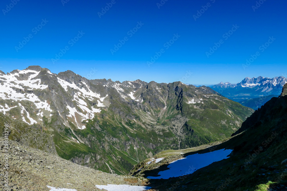 Massive mountain range of Schladming Alps, Austria. The slopes of Alps are steep, partially overgrown with green bushes. Dangerous mountain climbing.Clear and beautiful day. Endless mountain ranges,