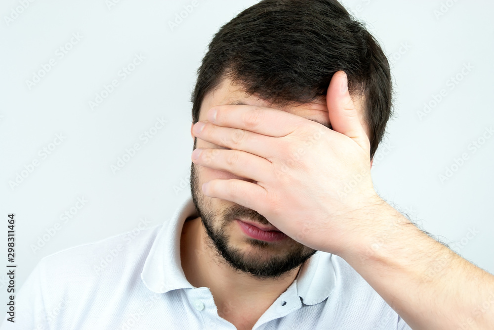 Closeup portrait of a bearded man holding palm over his face Closeup portrait of a bearded man holding palm over his face