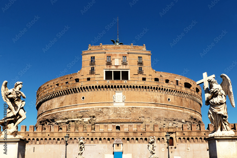 Facade of the Sant'Angelo Castle in Rome with statues of angels, and the blue sky in the background.