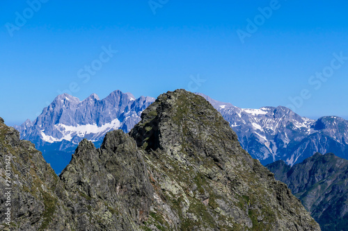 Massive  sharp stony mountain range of Schladming Alps  Austria. The mountain has a pyramid shape  it is partially overgrown with green bushes. Dangerous mountain climbing.Clear and beautiful day.