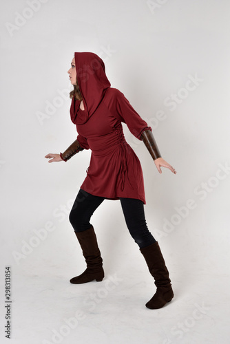 Obraz na plátně full length portrait of a brunette girl wearing a red fantasy tunic with hood