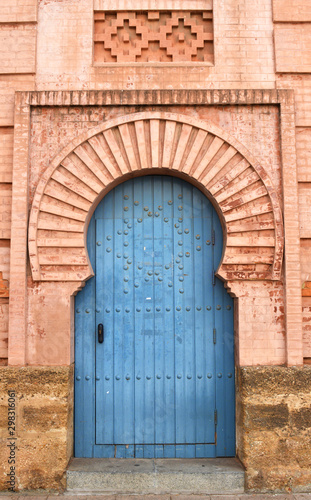 Fototapeta Naklejka Na Ścianę i Meble -  Beautiful Light Blue Door in a Warm Golden Red Brick Archway from Cadiz, Spain