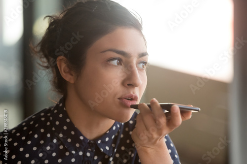 Indian woman recording audio message or using voice recognition photo