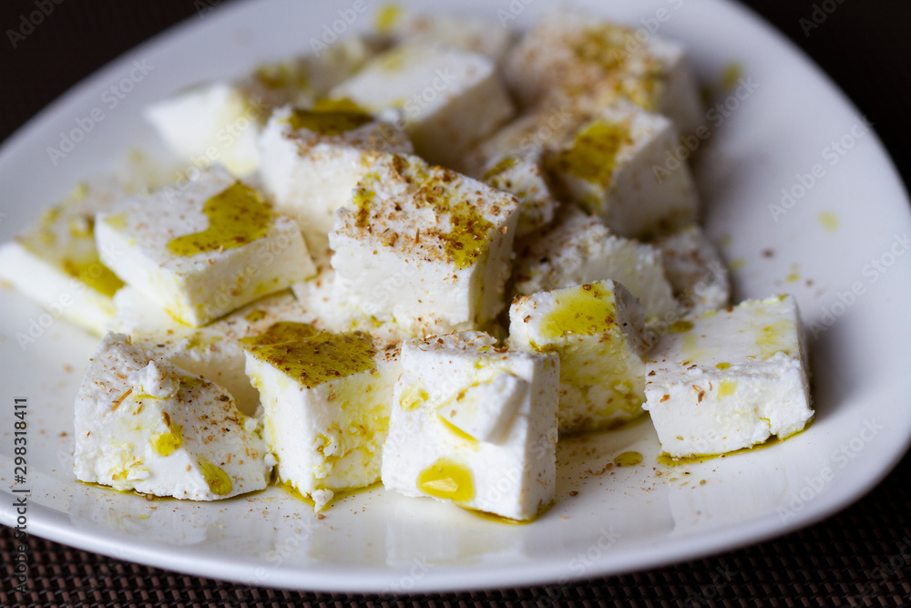 Slices of feta cheese with olive oil and spices Slices of feta cheese with olive oil and spices