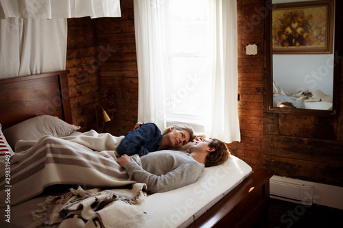 Billede på lærred High angle view of romantic couple looking at each other while relaxing on bed a