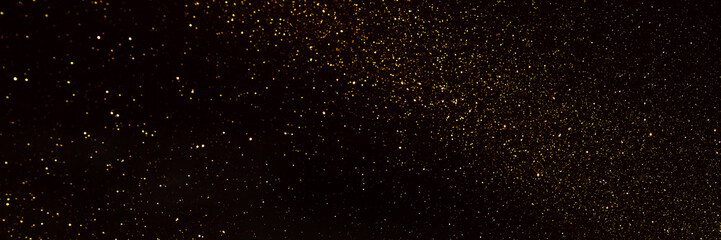 background of abstract glitter lights. gold and black. de focused. banner