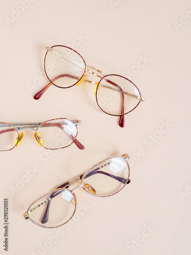 Set of retro eyeglasses isolated on light beige background. Flat lay. Top view. Copy space