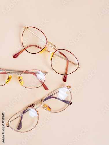 Set of retro eyeglasses isolated on light beige background. Flat lay. Top view. Copy space