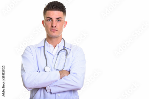 Studio shot of young handsome man doctor with arms crossed