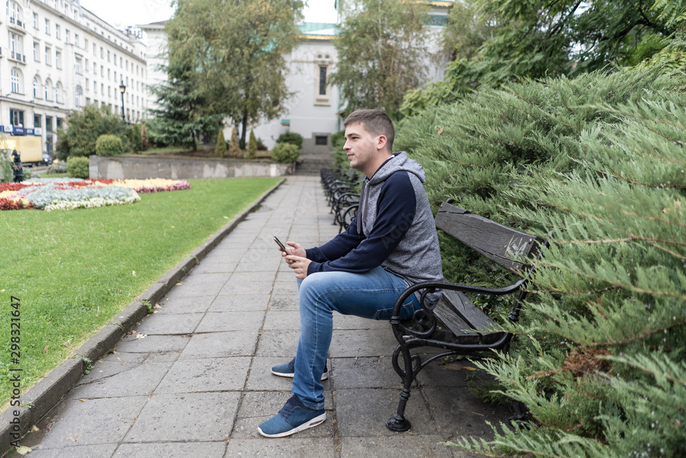 Young man using his mobile in the street Young man using his mobile in the street