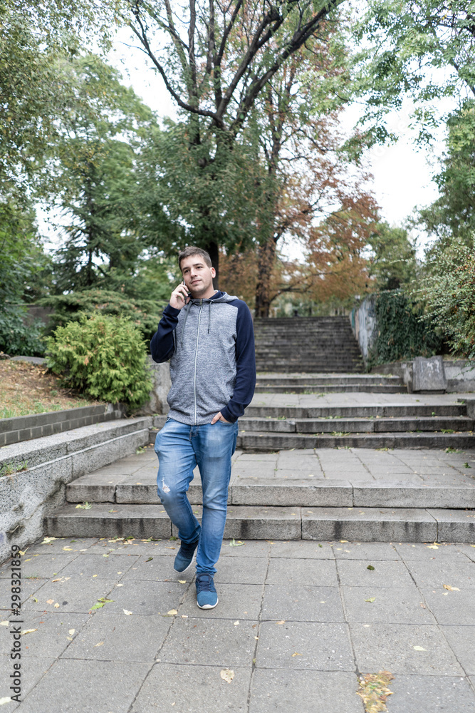 Fototapeta premium Young man using his mobile in the street