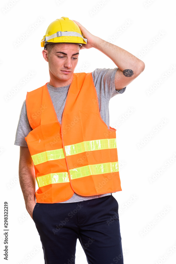 Studio shot of young handsome man construction worker holding sa Studio shot of young handsome man construction worker holding sa