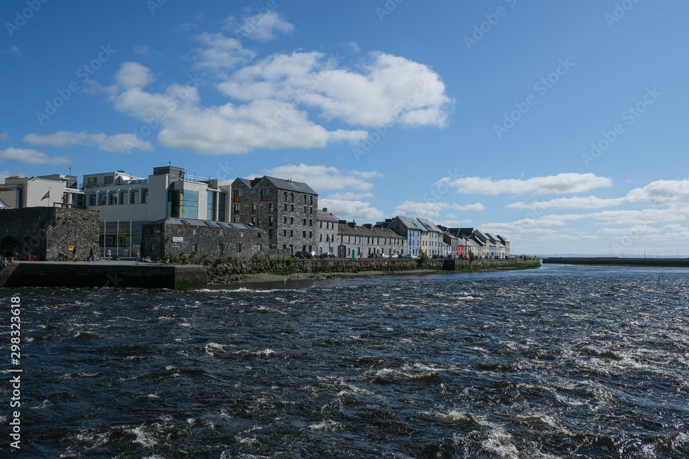 Famous view of the brightly painted houses of Galway city and the River Corrib rushing past on a sunny summer day