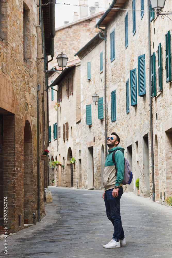 Young traveler walking the streets of San Quirico in Tuscany, Italy