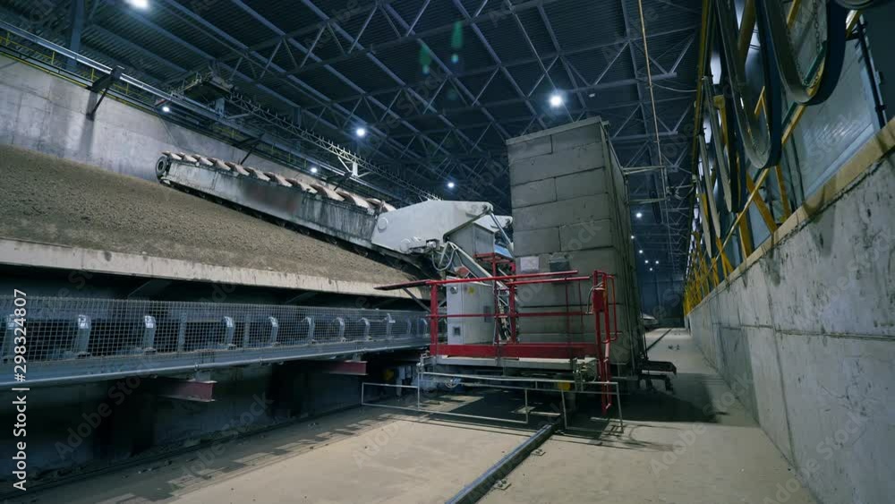 A machine works with sand and rubble at a factory. A machine works with sand and rubble at a factory.