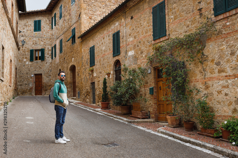 Young traveler walking the streets of San Quirico in Tuscany, Italy