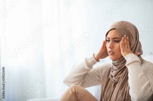 Muslim woman having a headache. Head ache face expression of Muslim woman wearing hijab. Young female feeling headache, suffering migraine symptom, health care, stress
