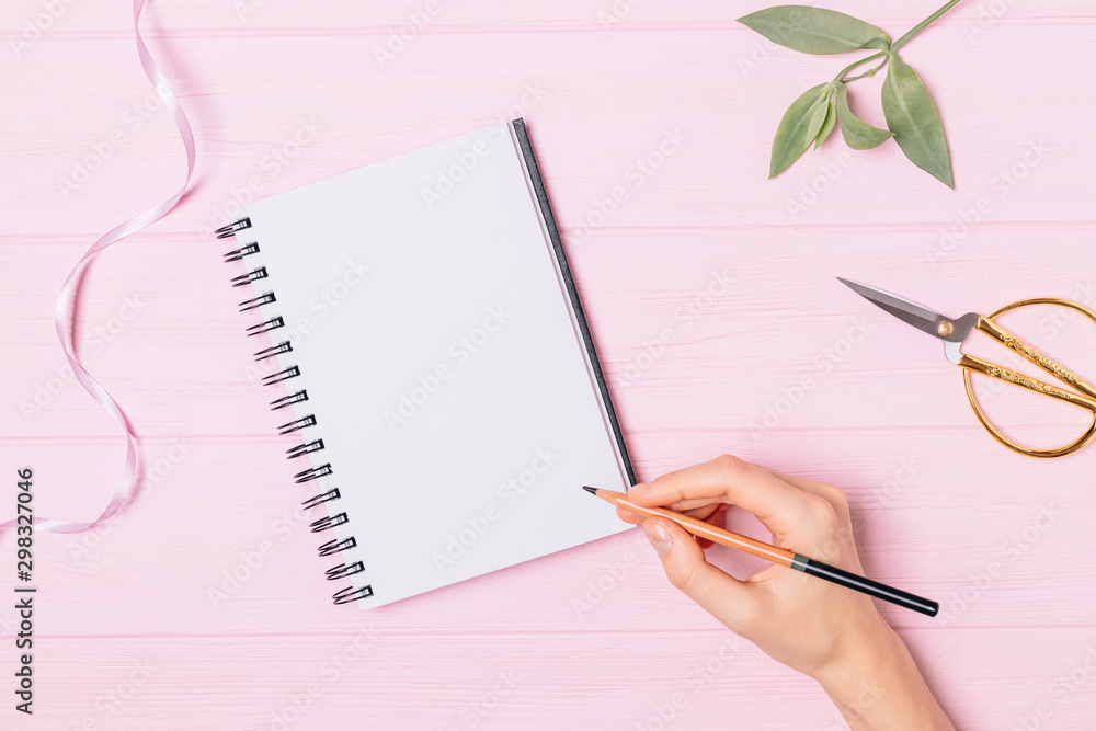 Female hand writing in empty notebook Female hand writing in empty notebook