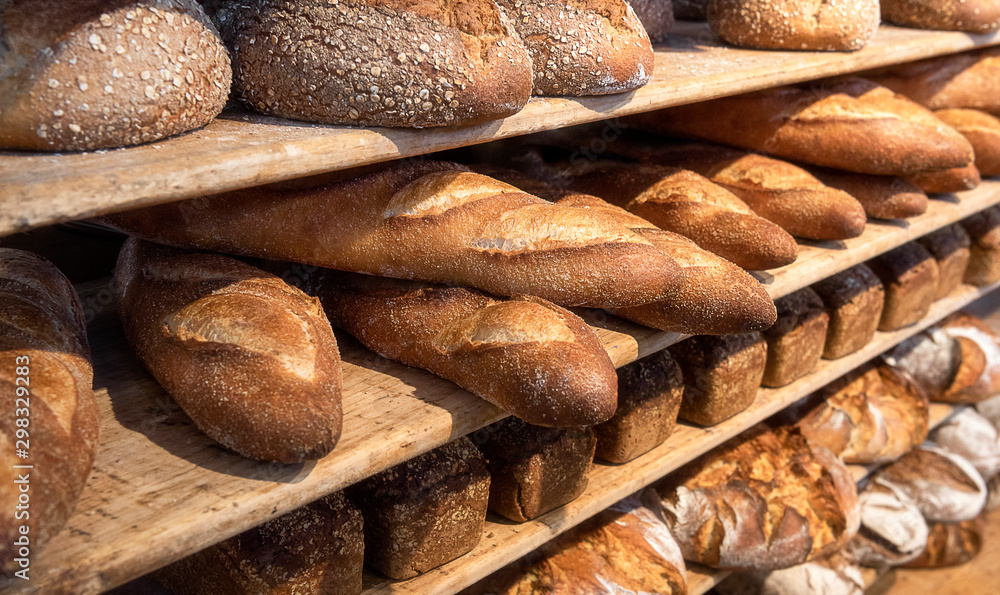 Bread variety on wooden shelves. Bakery goods. Freshly baked
