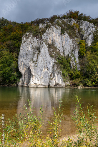 Danube river at Danube breakthrough near Kelheim, Bavaria, Germany in autumn with limestone rock formations and plants with colorful leaves © Reiner