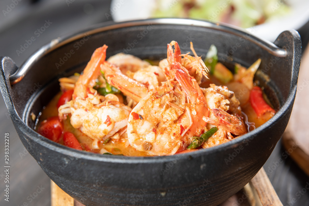 Chilli Soup with Shrimp or Tom Yum Kung is a popular Thai food and has a worldwide reputation, there is a hot and spicy taste of Thai identity and many ingredients with herb and serve in black bowl. Chilli Soup with Shrimp or Tom Yum Kung is a popular Thai food and has a worldwide reputation, there is a hot and spicy taste of Thai identity and many ingredients with herb and serve in black bowl.