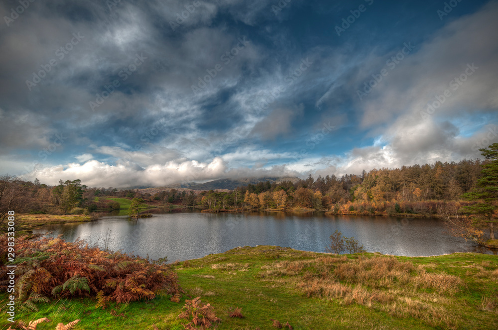 Stunning landscape image of Tarn Hows in Lake District during beautiful Autumn Fall.