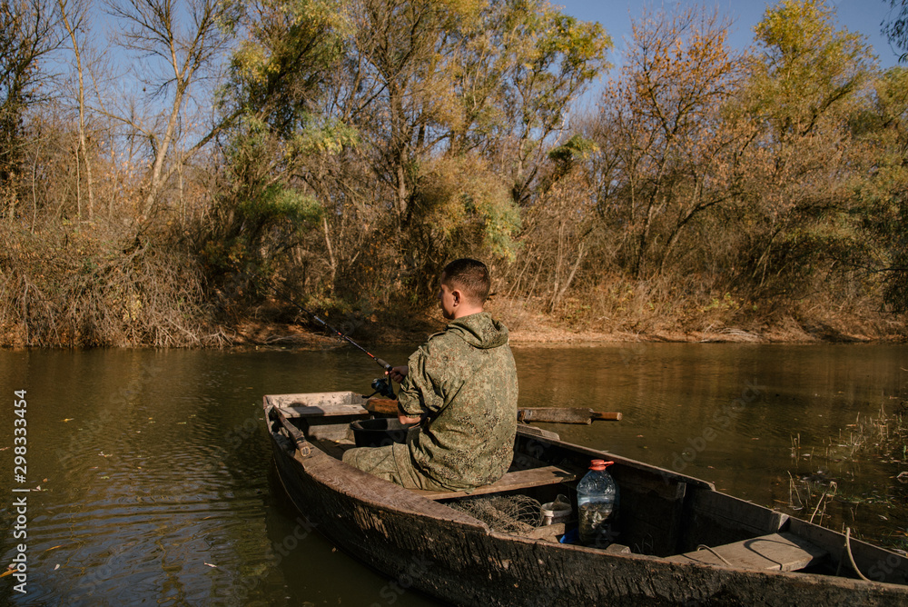 A fisherman is sitting in a boat and fishing A fisherman is sitting in a boat and fishing