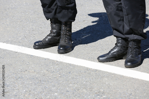 Φωτογραφία Legs of soldiers in black boots on the street