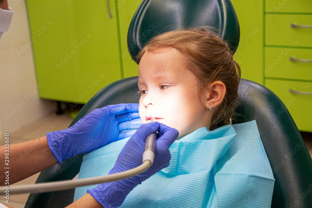 Little Caucasian girl treats teeth at the dentist Little Caucasian girl treats teeth at the dentist
