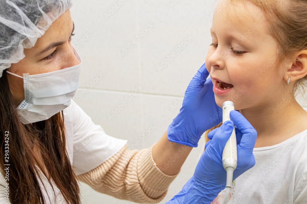 Dentist examines teeth of little Caucasian girl Dentist examines teeth of little Caucasian girl