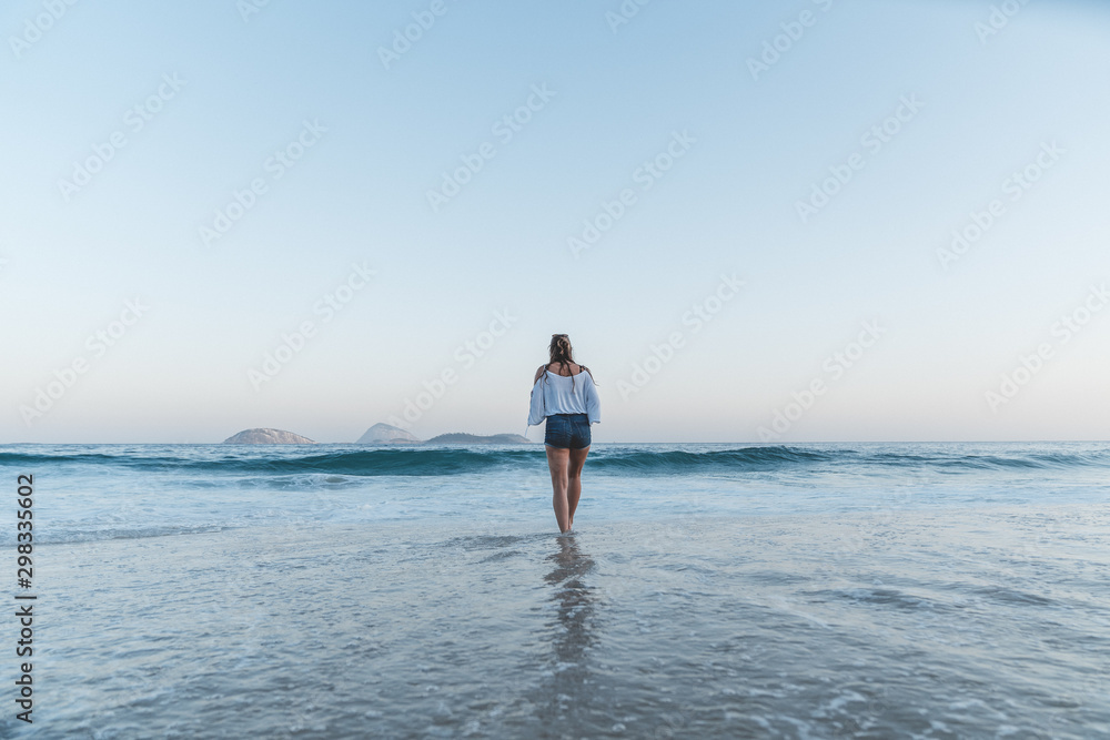 Femme marchant dans l'eau sur la plage