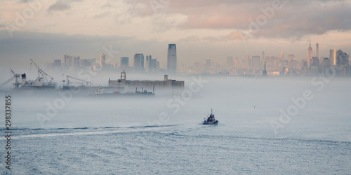 Boot fährt auf Hudson River in Nebelbank zwischen Jersey City und Manhattan