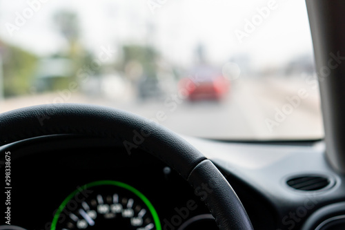 Steering wheel in front of car interface with road traffic view