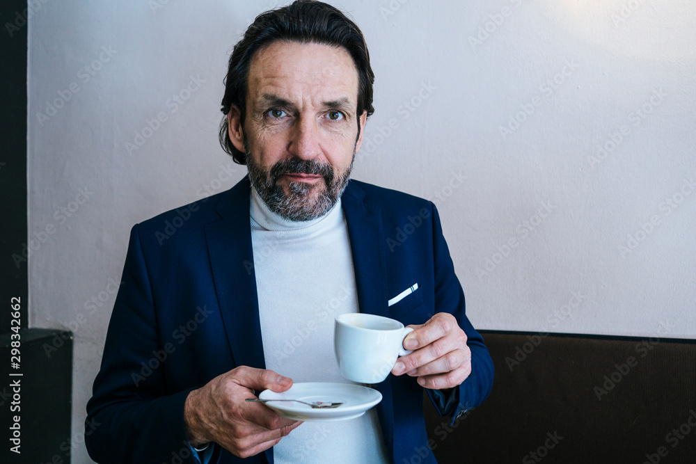 Portrait of mature businessman with cup of coffee in a cafe Portrait of mature businessman with cup of coffee in a cafe