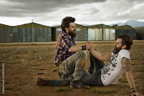 Two men with full beards reconciling after punch-up