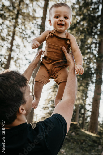 Happy father lifting up little son on a hiking trip in a forest, Schwaegalp, Nesslau, Switzerland photo