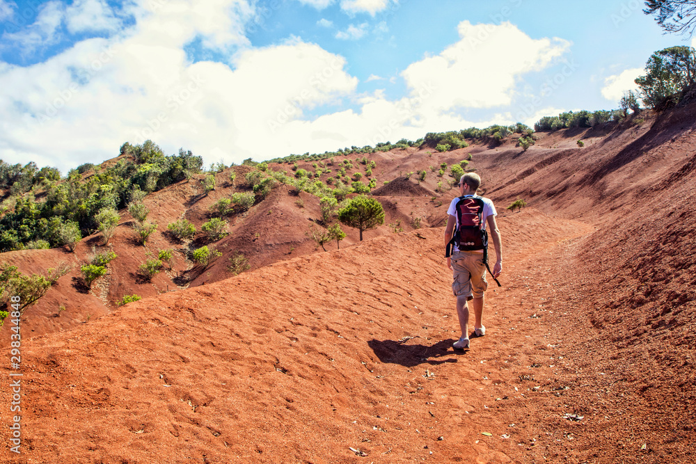 Hiker on red soil, Agulo, La Gomera, Canary Islands, Spain Hiker on red soil, Agulo, La Gomera, Canary Islands, Spain