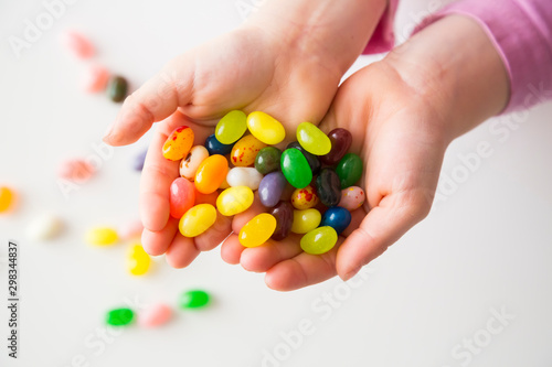 Hands of little girl holding jelly beans photo