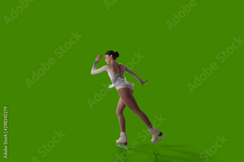 Картината върху платно Figure skating girl isolated on green background.