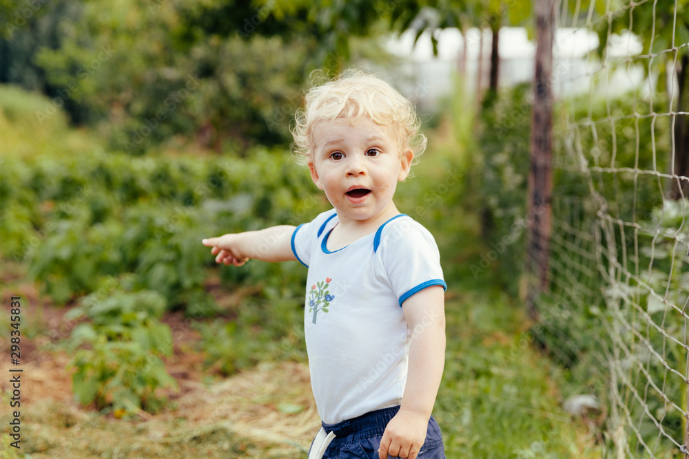 Toddler pointing at something in vegetable garden