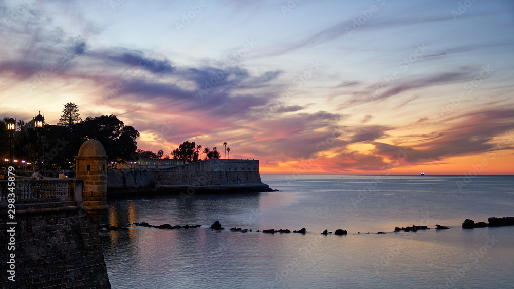 Amazing and Colorful Cloudy Sky at Dusk over Candelaria Bulwark Cadiz