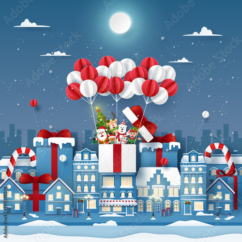Origami Paper art of cute Christmas character on balloon in town with snowing, Merry Christmas and Happy New Year